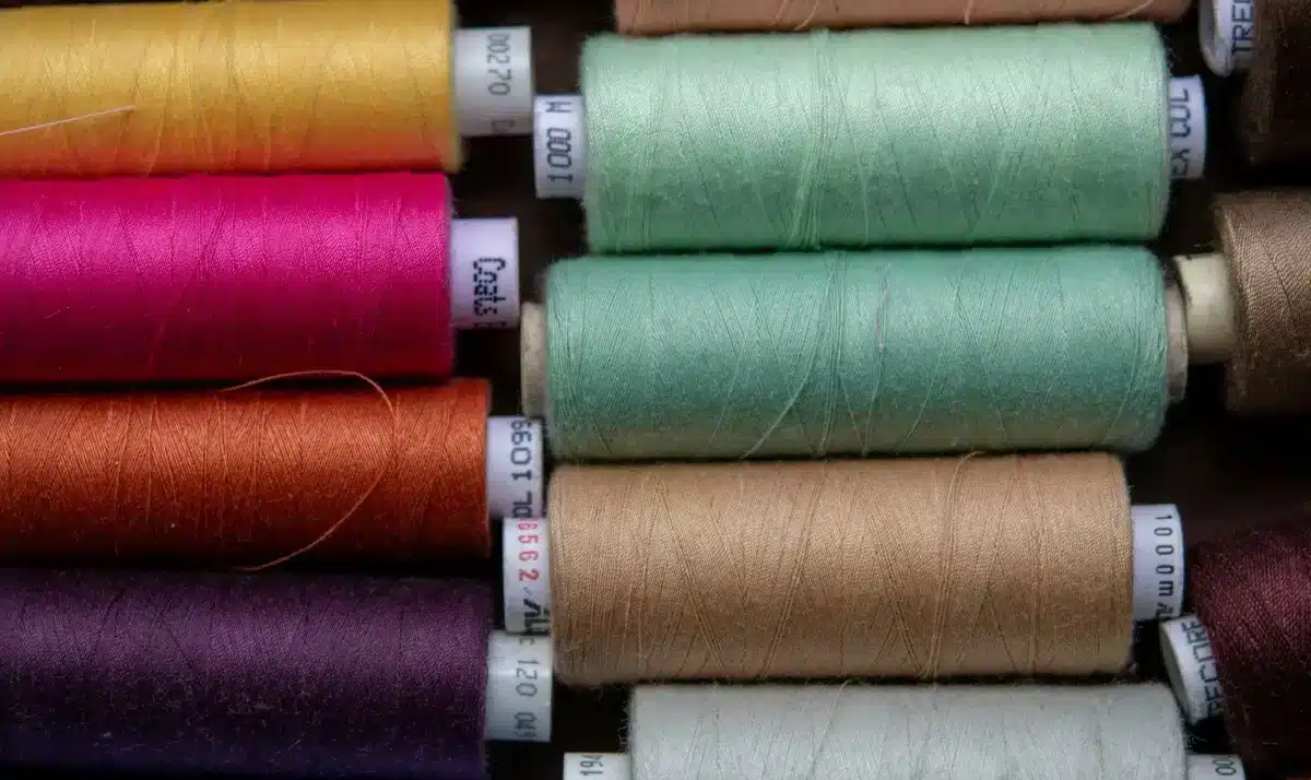PET- Thread Colorful spools of thread arranged in rows.
